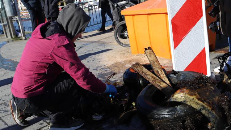 Ein freiwilliger Helfer sortiert den Müll, den die Taucher aus dem Hafenbecken gefischt haben.