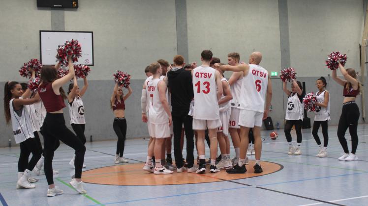Eingerahmt von ihren Cheerleadern feiern die Basketballer des TSV Quakenbrück ihren achten Saisonsieg.