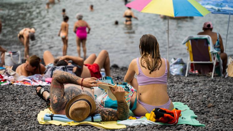 July 24, 2022, Puerto de la Cruz, Tenerife, Spain: People seen relaxing at Playa del Muelle beach in Puerto de la Cruz,