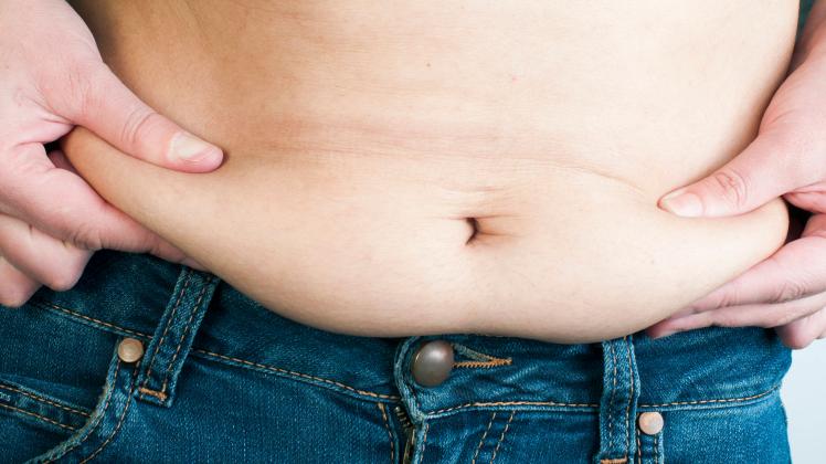 Woman pinching fat from her abdomen. Close up shot Copyright: xDeyanxGeorgievx/xDesignxPicsx , 32060110 PUBLICATIONxINxG