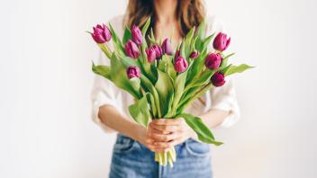 Woman holding a bouquet of purple tulips