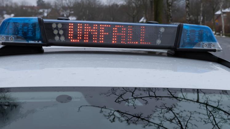 Ein Einsatzfahrzeug, Streifenwagen, der Polizei steht mit Blaulicht und dem Schriftzug Unfall in Display an einer Unfall