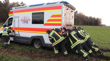 Kameraden der Hagenower Feuerwehr beim Versuch, den fest gefahrenen Rettungswagen auf dem Feld zwischen Steegen und Hagenow zu befreien. Hier half aber nur schwere Technik.