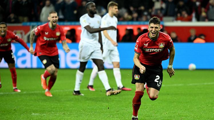 Leverkusen's Argentinian midfielder Exequiel Palacios (R) celebrates after scoring the 2-1 penalty goal during the German first division Bundesliga football match between Bayer Leverkusen and Bayern Munich in Leverkusen on March 19, 2023. (Photo by INA FASSBENDER / AFP) / DFL REGULATIONS PROHIBIT ANY USE OF PHOTOGRAPHS AS IMAGE SEQUENCES AND/OR QUASI-VIDEO