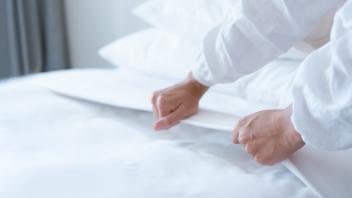 Female Hand set up white bed sheet in bedroom, Female Hand set up white bed sheet in bedroom, Female Hand set up white b