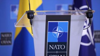 A picture taken at the NATO headquarters in Brussels shows Sweden and NATO flags before a press conference, on June 27, 2022. (Photo by Kenzo TRIBOUILLARD / AFP)