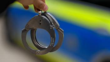 Themenbild Polizei Polizei Streifenwagen Polizist mit Handschellen Polizist mit Dienstpistole Ba