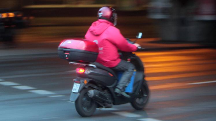 Motorroller fährt in der Abenddämmerung auf der Klosterstraße in Berlin Spandau Deutschland