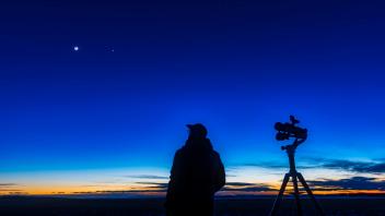February 27, 2020 - An astronomer looking at the waxing crescent moon near Venus, standing beside the Celestron SkyMaste