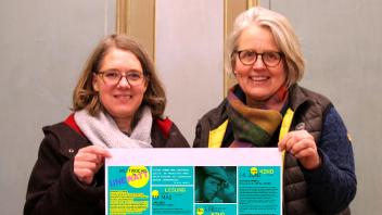 Inga Latendorf (li.) und Karen Precht von der Museumsleitung zeigen das Poster mit dem Sonderprogramm „Mittwochs in Unewatt“.