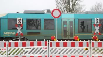 Ein Zug der NEG auf der Strecke Niebüll-Tondern passiert am 31.3.2023 den gesperrten Bahnübergang in der Uhlebüller Dorfstraße in Niebüll.