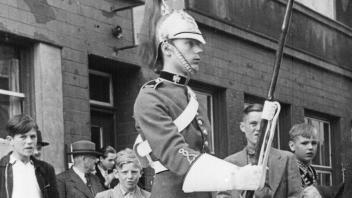 So wurde die Krönung von Charles Mutter in Neumünster vor 70 Jahren sichtbar: Wachsoldaten eines gehobenen königlichen Regiments waren im Sommer 1953 in besonderen Uniformen auf der Straße. Kleine Jungs bestaunten sie.