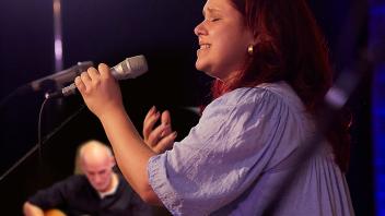 Ina Paul bei einem Auftritt mit Almost Pop, im Hintergrund der Band-Mastermind Detlef Winkel.