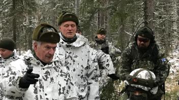 Finnlands Staatspräsident Sauli NIinistö (l.) bei einem Manöver im Wald.