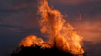 Osterfeuers als Symbol fuer Naturkraefte, Zerstoerung und Mythen Feuer auf einem Holzstapel am Abend mit Abendhimmel ***