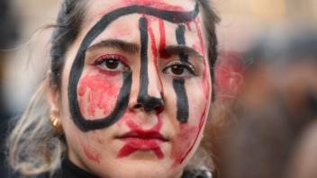 November 19, 2022, London, England, United Kingdom: Woman has painted Persian word symbolising Evin prison on her face.