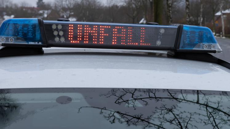 Ein Einsatzfahrzeug, Streifenwagen, der Polizei steht mit Blaulicht und dem Schriftzug Unfall in Display an einer Unfall