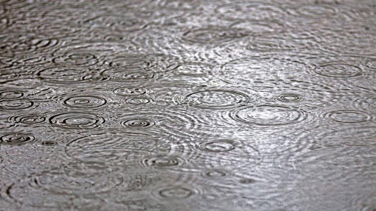 Regen auf Böden am Straßenrand Wassertropfen prasseln bei starken Regen auf dem Boden und bilden große Pfützen *** Rain 