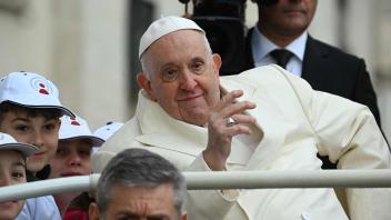 Papst Franziskus winkt in seinem Papamobil. 