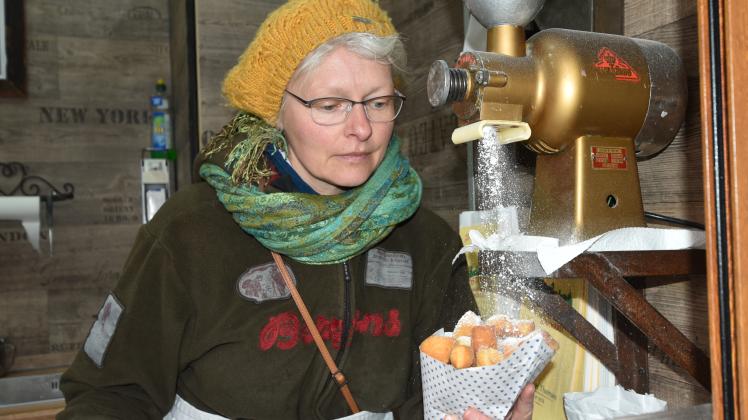Ein Hingucker am Mutzen-Stand: Die Puderzucker-Maschine ist eigentlich eine alte Kaffeemühle. Marion Günther verkauft die Quarkbällchen nach Traditionsrezept.