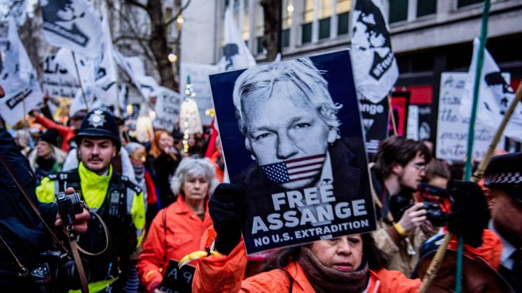 February 11, 2023, London, United Kingdom: Protesters in costumes hold placards during the Julian Assange procession in 