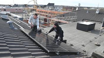 Über den Dächern von Itzehoe: Erik Andresen (l.) und Sven Wittmaack installieren Solar-Paneele auf dem St.-Laurentius-Heim. 