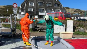 Nach dem Einsatz im Hotel Dorint werden die Feuerwehrleute mit Wasser abgespritzt.
