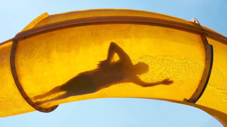 Silhouette of person sliding down water slide, BSCF00664