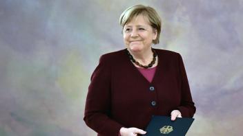 (FILES) In this file photo taken on October 26, 2021 German Chancellor Angela Merkel smiles after being handed her dismissal certificate by the German President during an official dismissal ceremony at the Presidential Bellevue Palace in Berlin. - On December 8, 2021, Angela Merkel left power, her popularity at the zenith. One year later, the star of the former German chancellor, considered too accommodating with Putin&apos;s Russia, has faded. (Photo by Jens Schlueter / AFP)