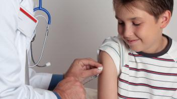 A child receives an immunisation or vaccination shot from a friendly doctor or healthcare worker. Copyright: xLeahxThomp