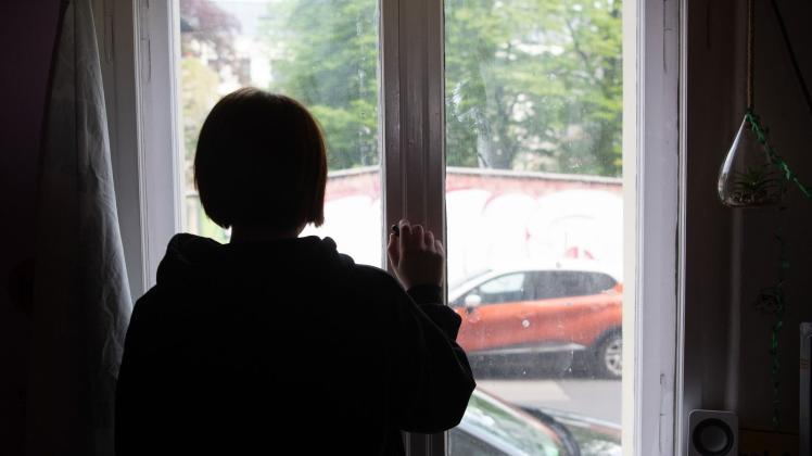 Eine Jugendliche blickt aus einem Fenster