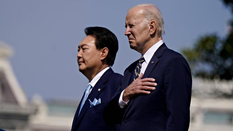 South Korean President Yoon Suk Yeol (L) and President Joe Biden listen to their national anthems at an arrival ceremony