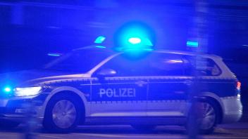 Hamburg, 31.10.2022 Ein Streifenwagen der Polizei ist in der dunklen Nacht mit Blaulicht in der Stadt unterwegs. Hambur