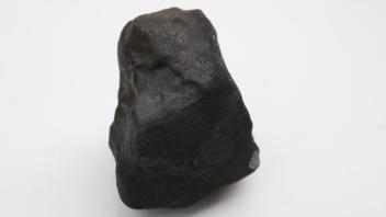 Wilfried Labusch zeigt den Stein, der in das Dach seines Hauses einschlug und bei dem es sich nach aller Wahrscheinlichkeit um einen Meteoriten handelt. Der Fund aus Schleswig-Holstein sorgt für viel Aufmerksamkeit.