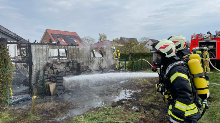 Mit reichlich Wasser und unter Atemschutz gingen die Feuerwehrleute gegen den Schuppenbrand in Neu Gülze vor.