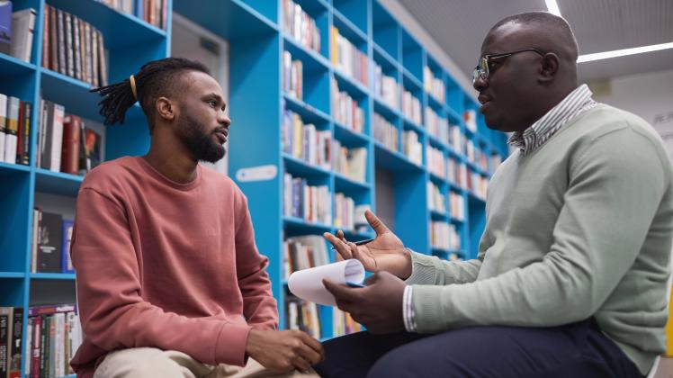 African American male therapist talking to student in mental health session