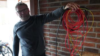 In seinem Carport zeigt Valentin Ertus die Kabel der PV-Anlage. Auf Wechselrichter und Speicher wartet er noch immer. 