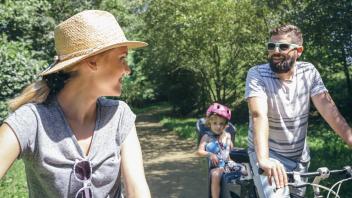 Couple talking while taking a family bike ride model released Symbolfoto PUBLICATIONxINxGERxSUIxAUTx