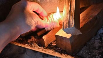 Heizen mit Holz. Das Holz im Kachelofen wird angezündet. Eisenärzt Bayern Deutschland *** Heating with wood The wood in