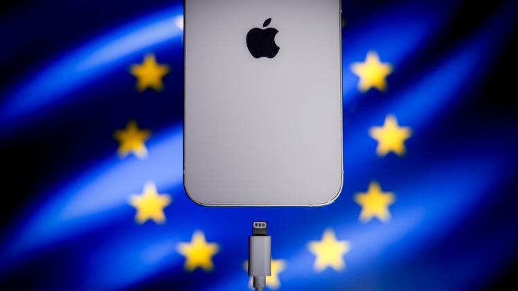 EU Passes Common Port Law For USB-C A Apple Lightning port charging cable is seen with with an iPhone with the EU flag i