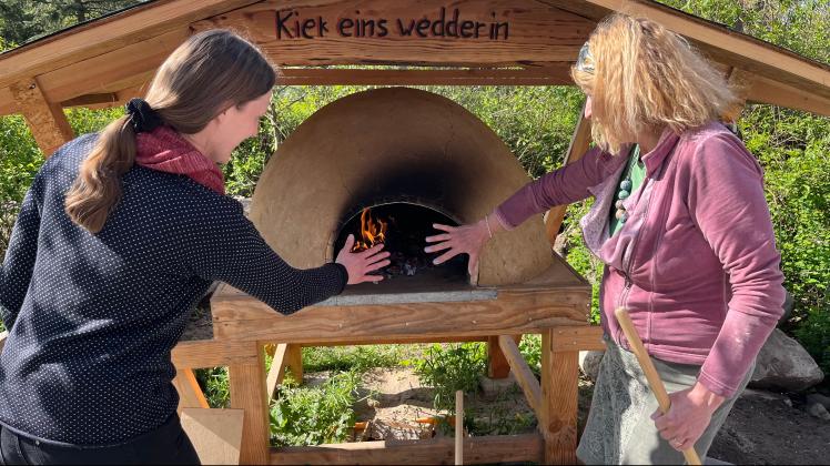 Ist der Ofen im Pfarrgarten von Gresse schon heiß genug für sein Premierenbrot? Johanna Montesanto (l.) und Edeltraut „Ede“ Kahl probieren es aus.