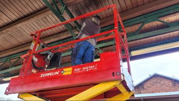 Arbeiter installiert Gitter gegen Tauben am Bahnhof Parchim