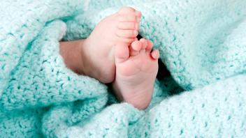 Two cute tiny baby feet wrapped in a blue-green aqua knitted blanket. Copyright: xPAULxHAKIMATAx/xDesignxPicsx , 3047254