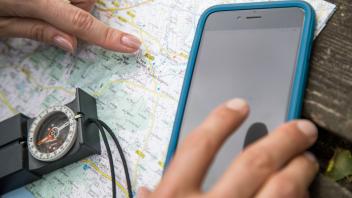Karte, Kompass, Smartphone bieten Orientierung