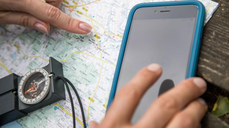 Karte, Kompass, Smartphone bieten Orientierung