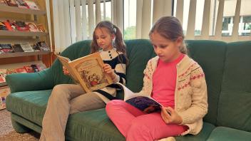Die ukrainischen Schülerinnen Karolina Demchenko (l., 4. Klasse) und Polina Drobot (3. Klasse) lesen in den neuen Büchern.