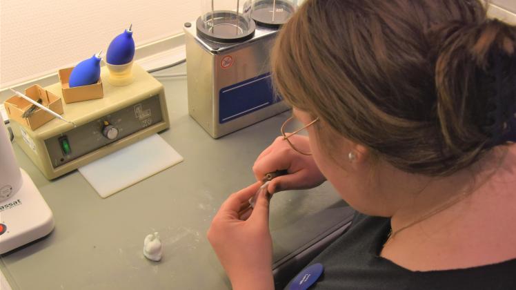 Die Auszubildende Anna Lange der Firma Kind Hörgeräte in Güstrow fräst die Abformung eines Ohres ab.