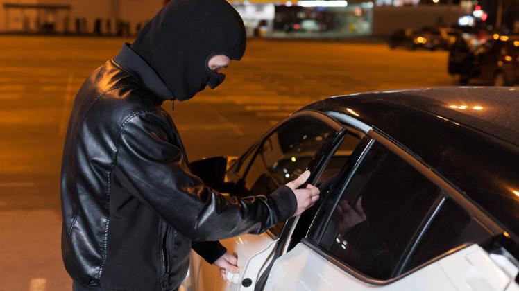 Male thief with balaclava on head opening car door Copyright: xNomadSoulx Panthermedia28095464 ,model released, Symbolfo