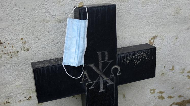 Grabkreuz mit Mundschutzmaske Grabkreuz mit Mundschutzmaske, 17.04.2021, Rassnitz, Sachsen-Anhalt Auf einem Grabkreuz li