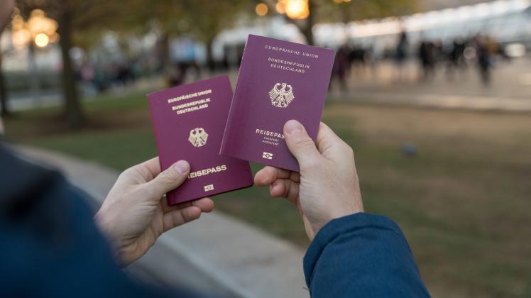 9 December 2022: A man holds two German passports in his hand. Passport *** Ein Mann hält zwei deutsche Reisepässe in de